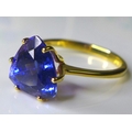 An 18ct gold and AAA tanzanite ring, the deep violet trilliant cut stone of approximately 3.3ct, 9 b... 