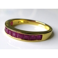 An 18ct gold and ruby half eternity ring, set with eleven square cut rubies, each stone approximatel... 