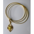 An 18ct gold triple faceted bangle, with sliding band set with a teardrop pendant depicting blind ju... 