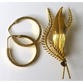 An 18ct gold brooch, modelled as a leaf with intertwining fern fronds, set with a garnet, 4.4g, toge... 