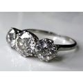 A platinum and diamond three stone ring, the central brilliant cut stone of approximately 1.5ct, 7.2... 
