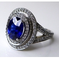 An 18ct white gold, sapphire and diamond dress ring, the dark cornflower blue oval cut stone of appr... 