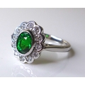 An 18ct white gold, tsavorite garnet and diamond dress ring, the stunning central oval cut stone of ... 