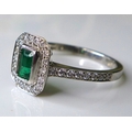 An 18ct white gold, emerald and diamond dress ring, the central emerald cut stone of approximately 0... 