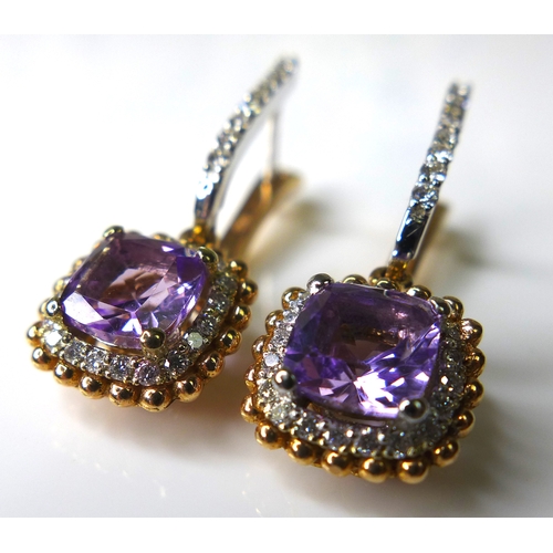 323 - A pair of 18ct white and rose gold, amethyst and diamond earrings, with central cushion cut amethyst... 