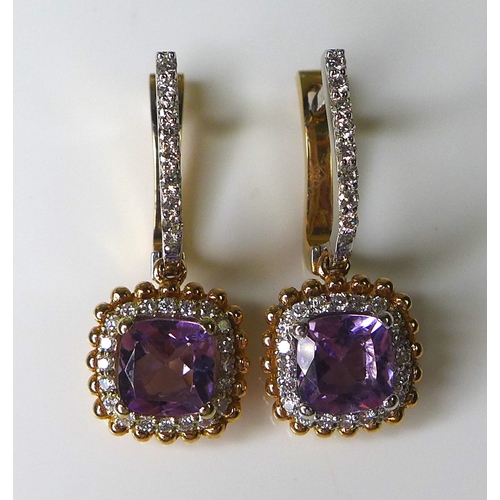 323 - A pair of 18ct white and rose gold, amethyst and diamond earrings, with central cushion cut amethyst... 