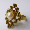 An 18ct gold ring of diamond shaped modernist design set with a central pearl, size 0, 5.3g.