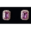 A pair of 18ct white gold, pink sapphire and diamond ear stud earrings, each set with a central emer... 