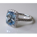 An 18ct white gold, aquamarine and diamond ring, the central cushion cut aquamarine of approximately... 
