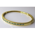 A 14ct gold, emerald and diamond bangle, set with alternating brilliant cut emeralds and diamonds, t... 