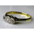 An 18ct gold and platinum three stone diamond ring, illusion set, central stone 0.1ct, size N, 2.3g.