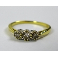 An 18ct gold three stone diamond ring, size O/P, central stone of approximately 0.13ct, 3.35mm diame... 