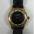 A vintage Nuclea De Luxe gold plated gentleman's wristwatch, with circular black dial, dot markers, ... 