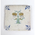 A 17th century Delft polychrome tile, decorated with a central flower and with a fleur-de-lis to eac... 