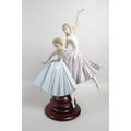A large Lladro figural group, modelled as a pair of ballerinas, with turned wooden base, 50cm high i... 