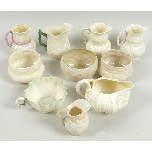 43 - A collection of Belleek jugs and sugar bowls, comprising a Toy Shell creamer jug with yellow lustre,... 