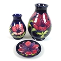 Two Moorcroft Pottery vases and a pin dish, all decorated in 'Anemone' pattern, both vases of balust... 
