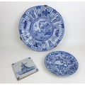 Three pieces of 19th century Delft blue and white ceramics, a later 19th century charger with a rive... 