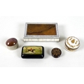 A small group of boxes, comprising a white metal box with red stone cabochon to lid, a black snuff b... 
