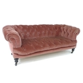 A Victorian Chesterfield settee, two seater, upholstered in buttoned pink velvet, raised on ebonised... 