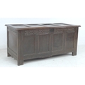 An 18th century oak chest, lift lid with loop hinges, four panel front below a carved frieze, on sti... 