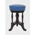 A 20th century stained oak piano stool, with swivel leatherette seat with turned central urn column ... 