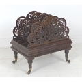 An Edwardian burr walnut Canterbury, with pierced carved ends, raised upon turned legs and brass cas... 