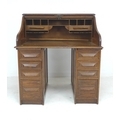 An oak roll top desk, circa 1940, made by Cutler, twin pedestals each with four drawers, fitted inte... 