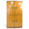 An Art Deco birds eye maple veneered cocktail cabinet, bow fronted, with twin doors opening to revea... 