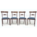 Four 20th century mahogany dining chairs with drop in seats, raised upon sabre legs. (4)
