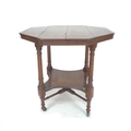 A Victorian oak centre table, octagonal surface, turned supports, lower tier shelf and brass castors... 