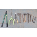 A group of garden tools, including rakes, hoes, spade, fork, lopper, hammers, hedge cutters, and a h... 