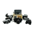 A group of vintage cameras, including a Nikon, an Olympus Trip 35, a Kodak Automatic Super 8 cine ca... 