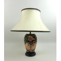 A Moorcroft Pottery Oberon pattern table lamp, of ovoid form with circular wooden base and complimen... 
