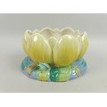 A Clarice Cliff for Newport Pottery planter, circa 1940, formed as a water lily, painted in yellows,... 