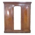 A late Victorian mahogany wardrobe, of three sections, with central full length mirror door, fitted ... 