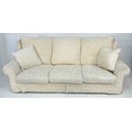 A modern large three seater sofa, of wingback style, upholstered in cream foliate cotton, 220 by 97 ... 