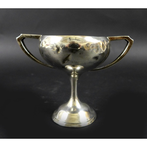 40 - A group of silver items comprising two trophies, 7.76toz, and three teething rattles, one in the for... 