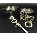 A group of silver items comprising two trophies, 7.76toz, and three teething rattles, one in the for... 