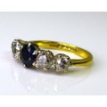 An 18ct gold, sapphire and diamond ring, the sapphire 4 by 4.5mm, flanked by two graduated diamonds ... 