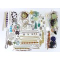 A quantity of costume jewellery, including a mother of pearl carved pendant, a number of jade carved... 