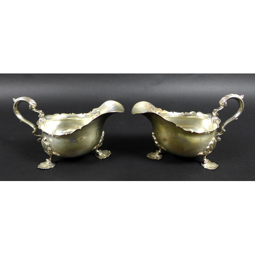 67 - A pair of Victorian silver sauce boats, both with shaped handles, and three shell mounted legs, each... 