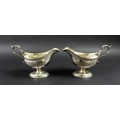 A pair of George III silver pedestal sauce boats, with bright cut decoration and engraved with the i... 