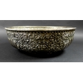 A late 19th century Thai silver large bowl, repousse decorated in relief with three face masks and t... 