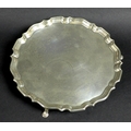 A George V silver tray, of circular form with Chippendale pie crust edge, raised on three feet, reta... 