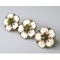A silver and enamel brooch of apple blossom design, 1930s, composed of three blossoms in a row, enam... 