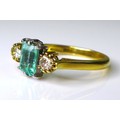 An 18ct gold, emerald and diamond ring, the central emerald cut stone of peppermint green colour and... 