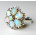An 18ct white gold and opal dress ring, of flower head form, with six oval opals surrounding a centr... 