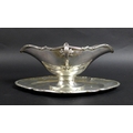 A French silver sauce boat and stand, the sauce boat with scalloped rim, the twin handles and rim wi... 