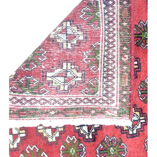 307 - A Turkman runner, with red ground and multiple guls to field, narrow borders, 295 by 83cm.